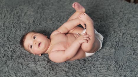 top view of baby girl lying on her back and looking around