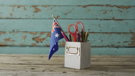 australian flag with stars and stripes with school items on wooden table