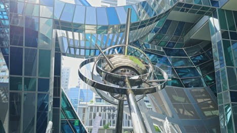 abstract metallic sculpture amidst modern glass architecture
