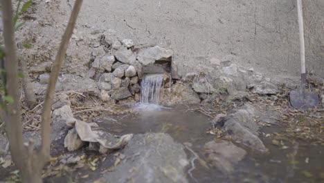 traditional irrigation watering system open air canal transfer water from qanat to garden orange orchard dates palm tree grooves nayband tabas iran desert historical agriculture local people persian