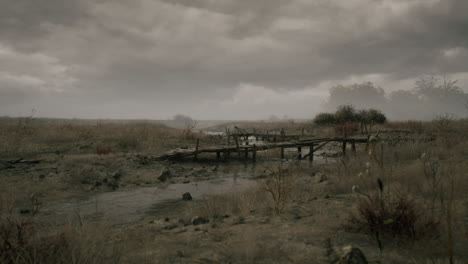 dry landscape with a wooden bridge under a cloudy sky at dusk