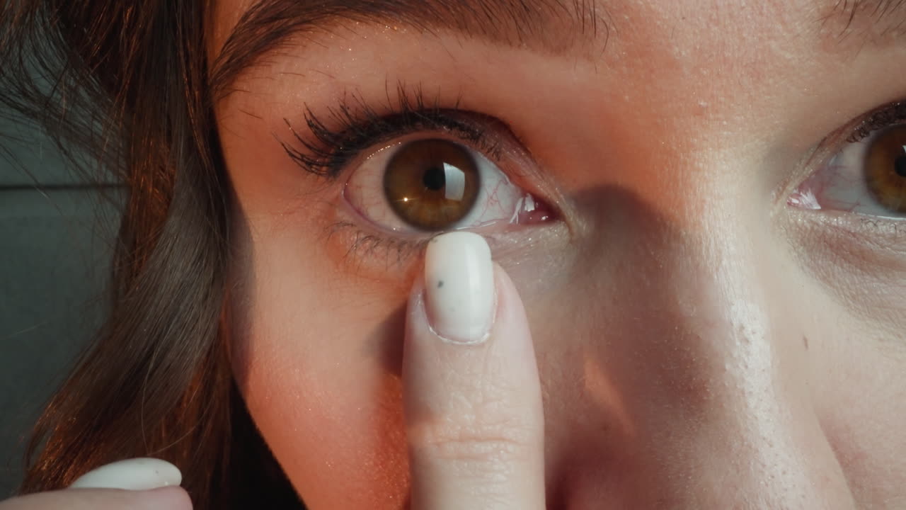 Woman blends concealer under eye with finger to cover flaws