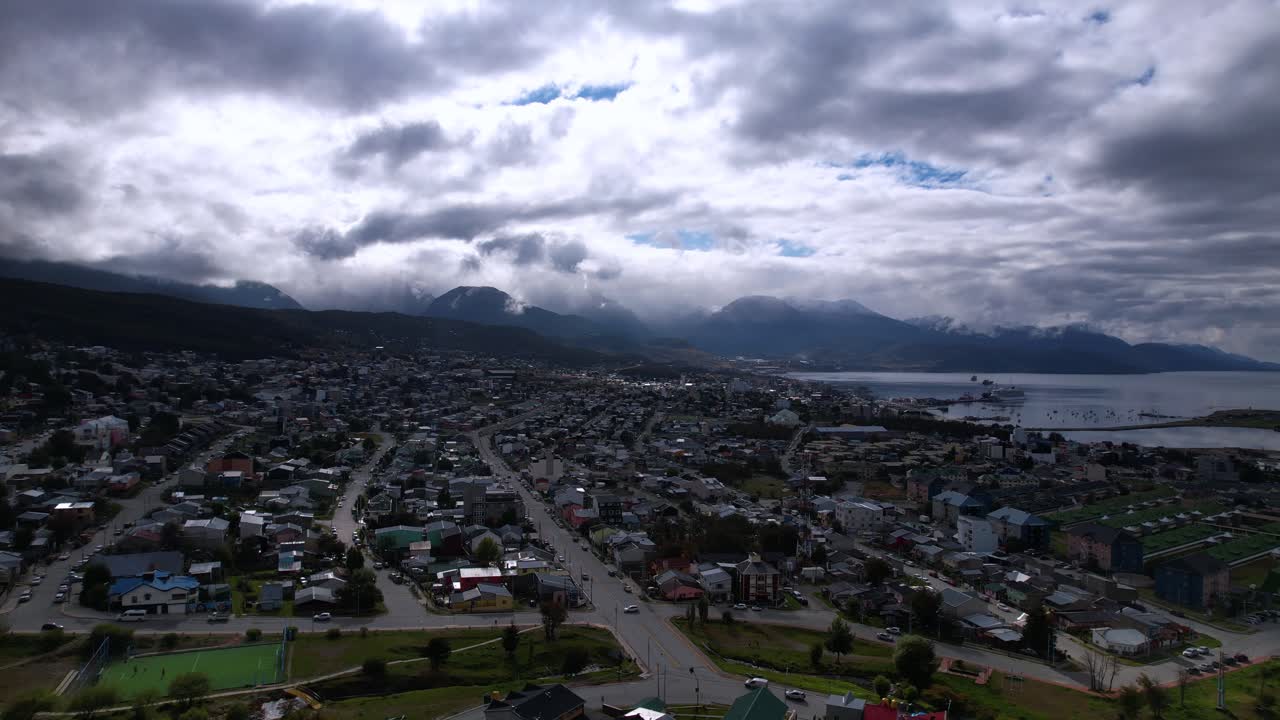 Aerial Drone Footage Showcases Ushuaia Village In Argentina, Revealing Stunning Mountain Views. The Dark Clouds Create A Moody Atmosphere On This Cloudy Summer Day in 4K