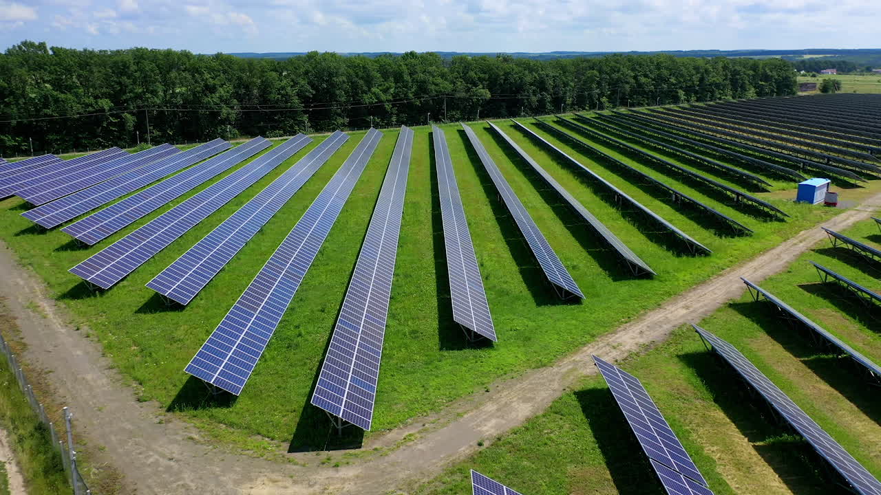 Kameravisning i bevægelse af solpanelerne med en baggrund af blå himmel. Alternativ energi. Grønt energikoncept. Elproduktion. Økoanlæg. Luftfoto af celle