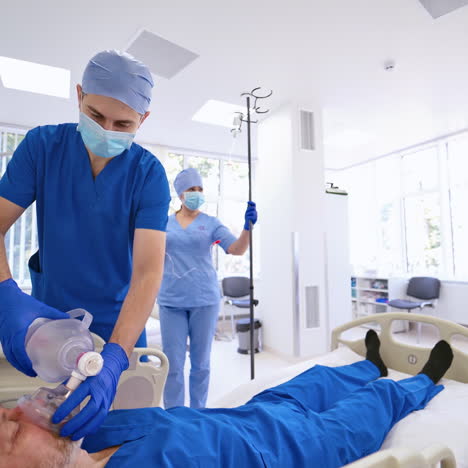 doctor is saving patient's life in clinic. modern emergency room background and male doctor gives resuscitation to a man lying in bed.