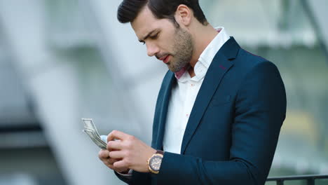 portrait man counting money at street. businessman smiling in stylish suit