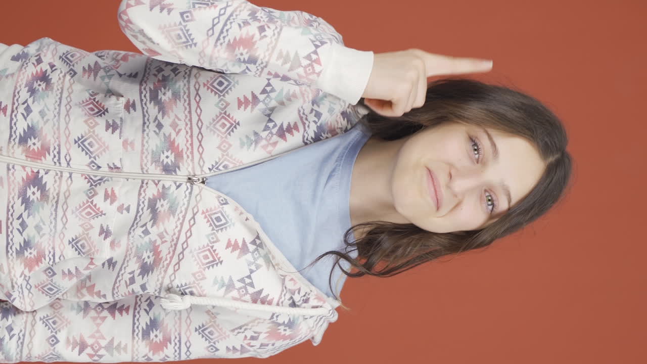 카메라에 마음을 보여주는 젊은 여성의 수직 비디오.