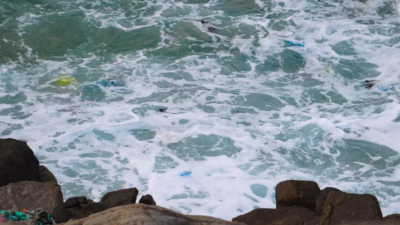 Colorful plastic rubbish polluting turquoise sea water at coast of Vietnam