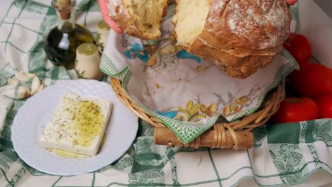 Ein-Riesiges-Stück-Sauerteigbrot-Auf-Dem-Tisch-Brechen,-Mit-Einem-Teller-Mit-Köstlichem-Tofu,-Der-Mit-Zitronensauce-An-Der-Seite-Belegt-Ist---Hochwinkelaufnahme,-Zeitlupe