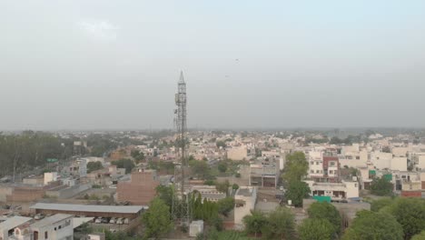 una bandada de palomas volando en el cielo azul alrededor de la torre móvil ubicada en la zona residencial de la ciudad en punjab