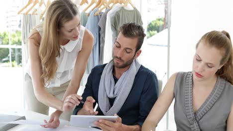 Fashion-design-team-working-together-at-table-with-tablet-pc