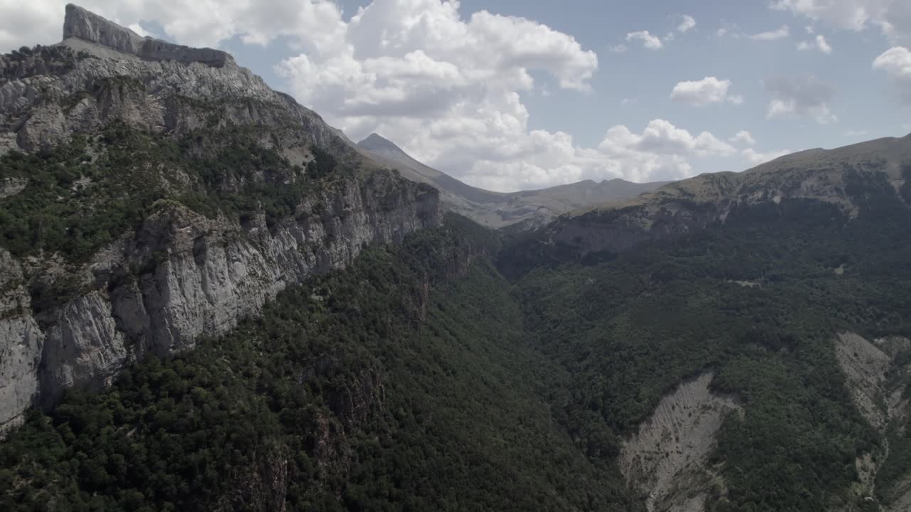 4K panning drone shot over the mountains of Hecho Valley in the Western Valleys Natural Park, Aragonese Pyrenees, Spain. A breathtaking aerial view of the rugged and untouched landscape.