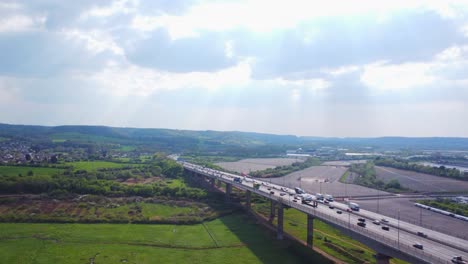 acceding drone shot rising above bristols river avon to reveal traffic on avonmouth bridge on southbound m5 motorway