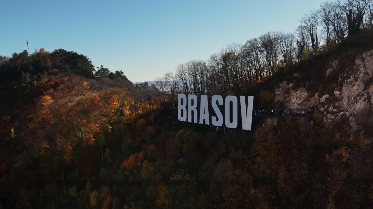 Brasov sign on the top of the hill near the city, yellowed trees, Romania