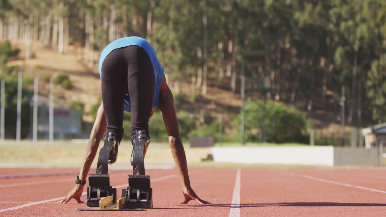 hombre de raza mixta discapacitado con piernas protésicas mirando una carrera