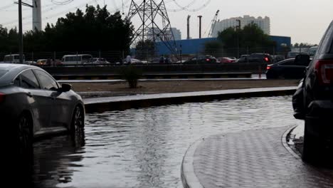 black sedan car stuck in a flooded narrow road in dubai, united arab emirates after a heavy rain on november 26, 2018