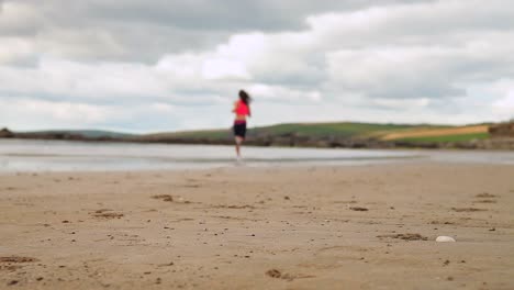 Athletic brunette running on the beach