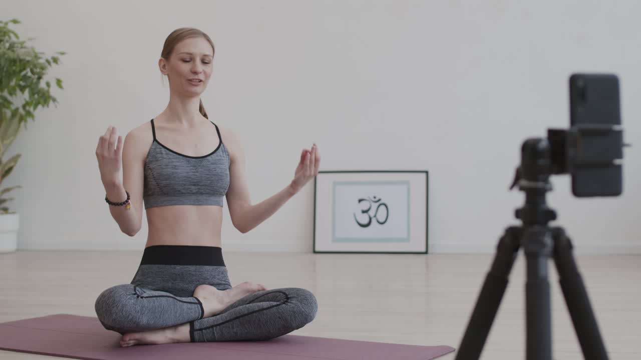 yogi mujer filmando su práctica de yoga en video