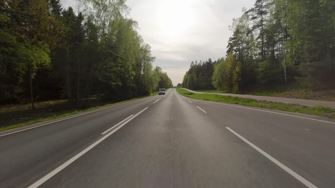 Kombinace silnice, stromů a otevřených polí vytváří harmonickou krajinu, kde příroda a lidská činnost koexistují v dokonalé symbióze.