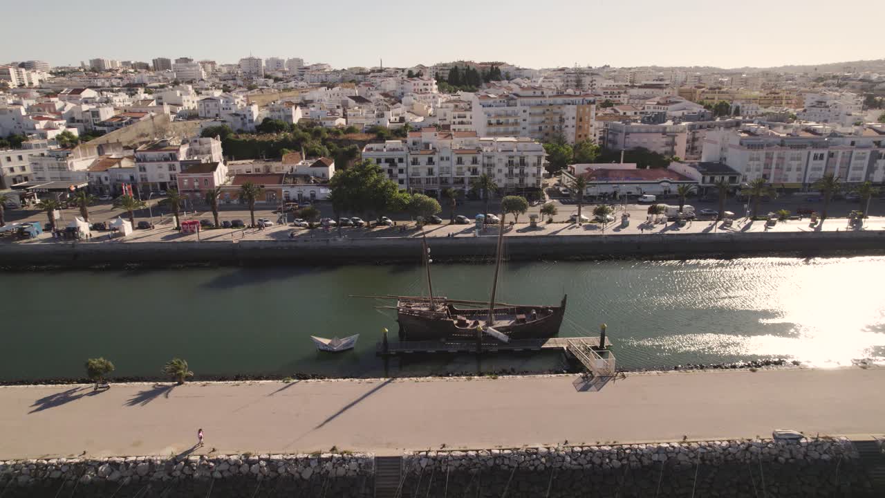 Old vessel sitting in the canal of Lagos, Portugal in front of the picturesque skyline