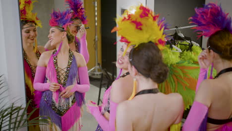 female dancer getting ready in front of the mirror for the show while talk and smile