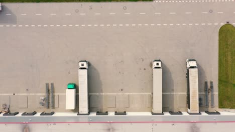 Aerial-view-of-the-logistics-warehouse-with-trucks-waiting-for-loading