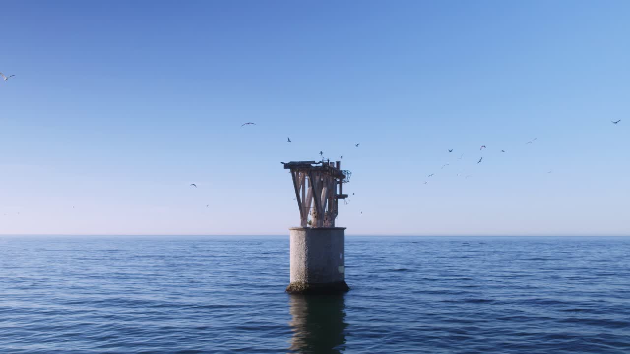 torre abandonada en el mar con gaviotas volando