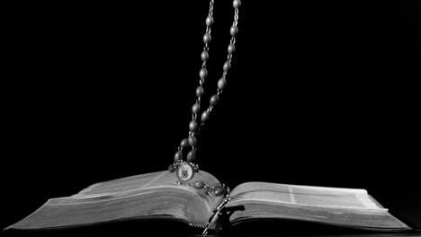 rosary beads falling onto open bible