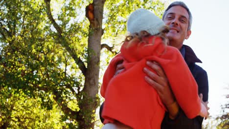 niña levantada por su padre al aire libre