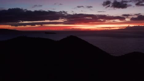 Low-dolly-aerial-shot-behind-cinder-cone-crater-with-Kaho'olawe-and-Molokini-in-the-distance-at-twilight-on-the-island-of-Maui,-Hawai'i