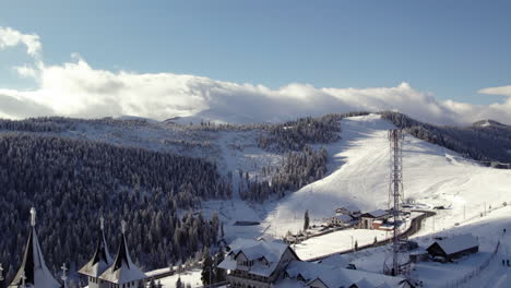 Church-amidst-snowy-mountain-peaks,-aerial-perspective