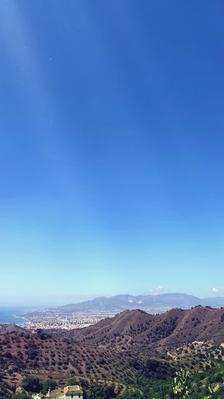 Paisaje panorámico y soleado de una ciudad costera, el mar y las montañas