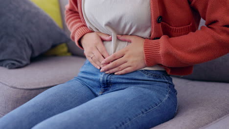 dolor de estómago, calambres y manos de mujer en el salón