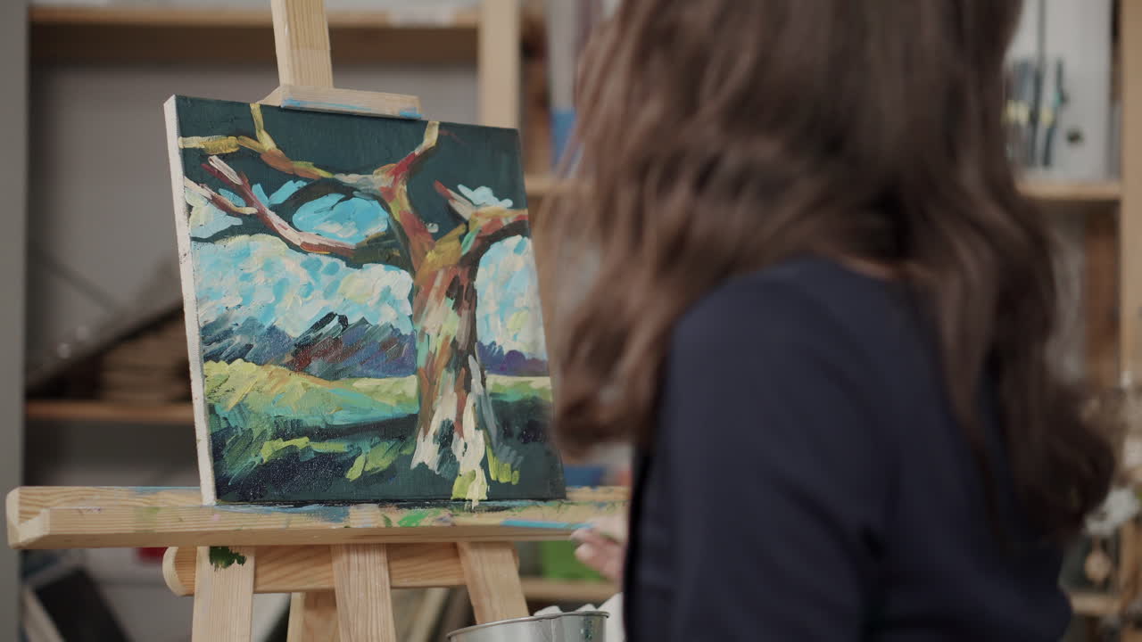 mujer pintando un paisaje de árbol