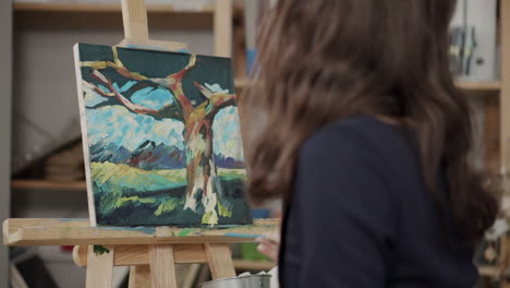 woman painting a tree landscape