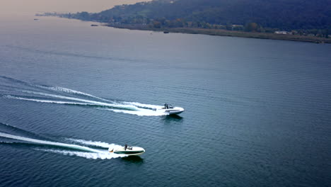 Vista-Aérea-Cinematográfica-De-Drones-De-Dos-Lanchas-Rápidas-Compitiendo-En-El-Lago-Iseo,-Italia