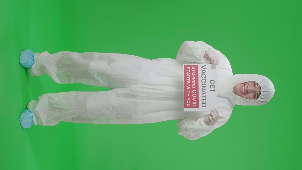 Full Body Of Asian Man Wearing Personal Protective Equipment Uniform Ppe And Holding Get Vaccinated Stopping Covid Starts With You Sign In The Green Screen Studio