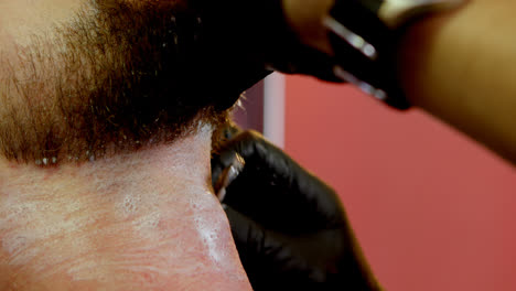 hombre que se afeita la barba con una navaja 4k