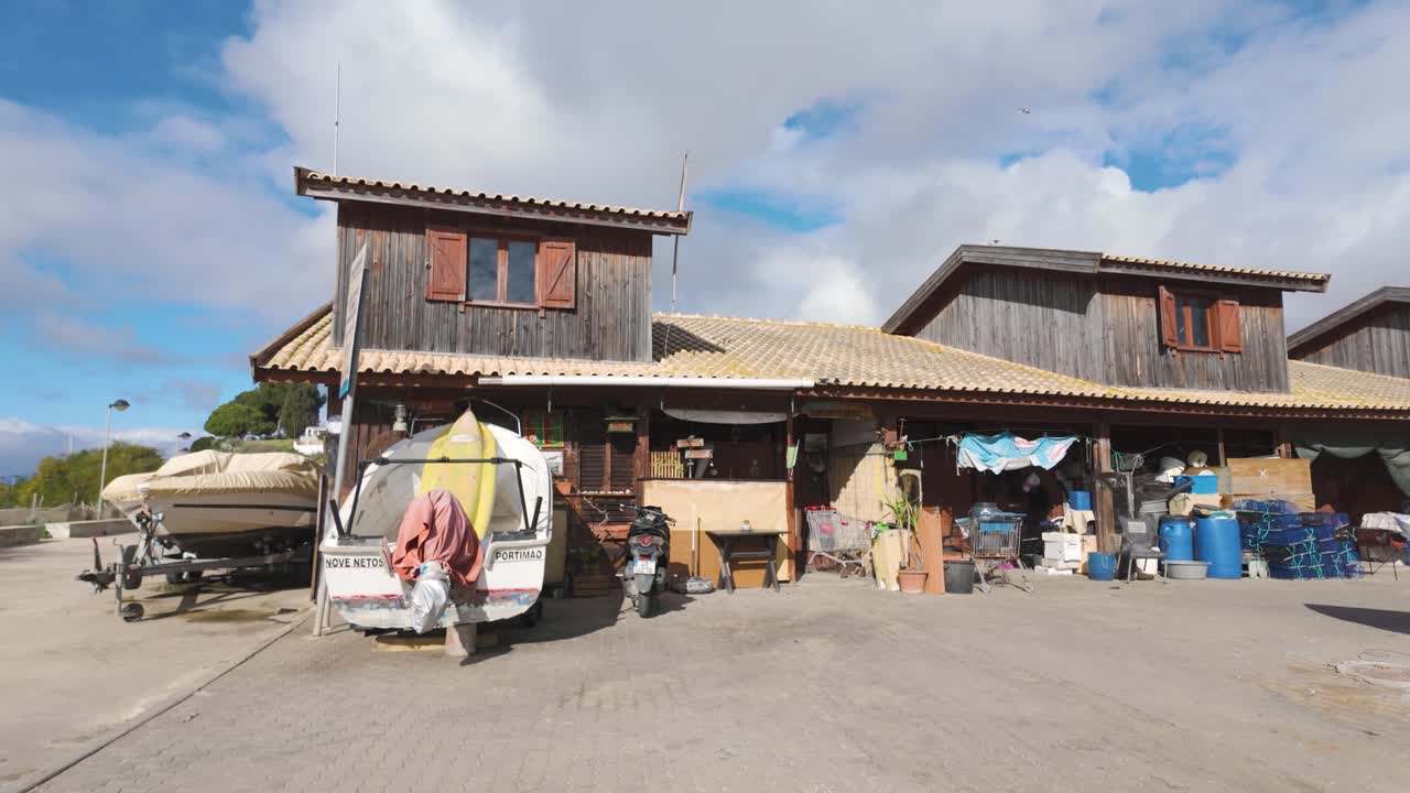 Rustic fishing harbour in Alvor, Algarve, Portugal, with boats, nets, and wooden huts