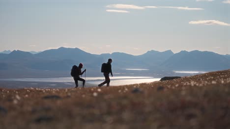 couple hiking together on måtinden mountain with scenic views of the landscape