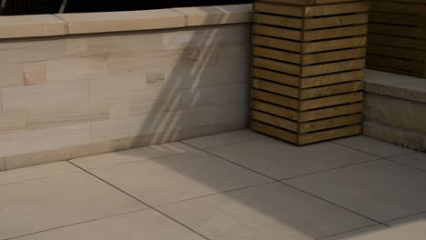 Afternoon-light-softly-hitting-luxury-paving-stones-in-back-garden-on-summers-day-with-lots-of-soft-whites-yellow-and-beige-sand-slabs