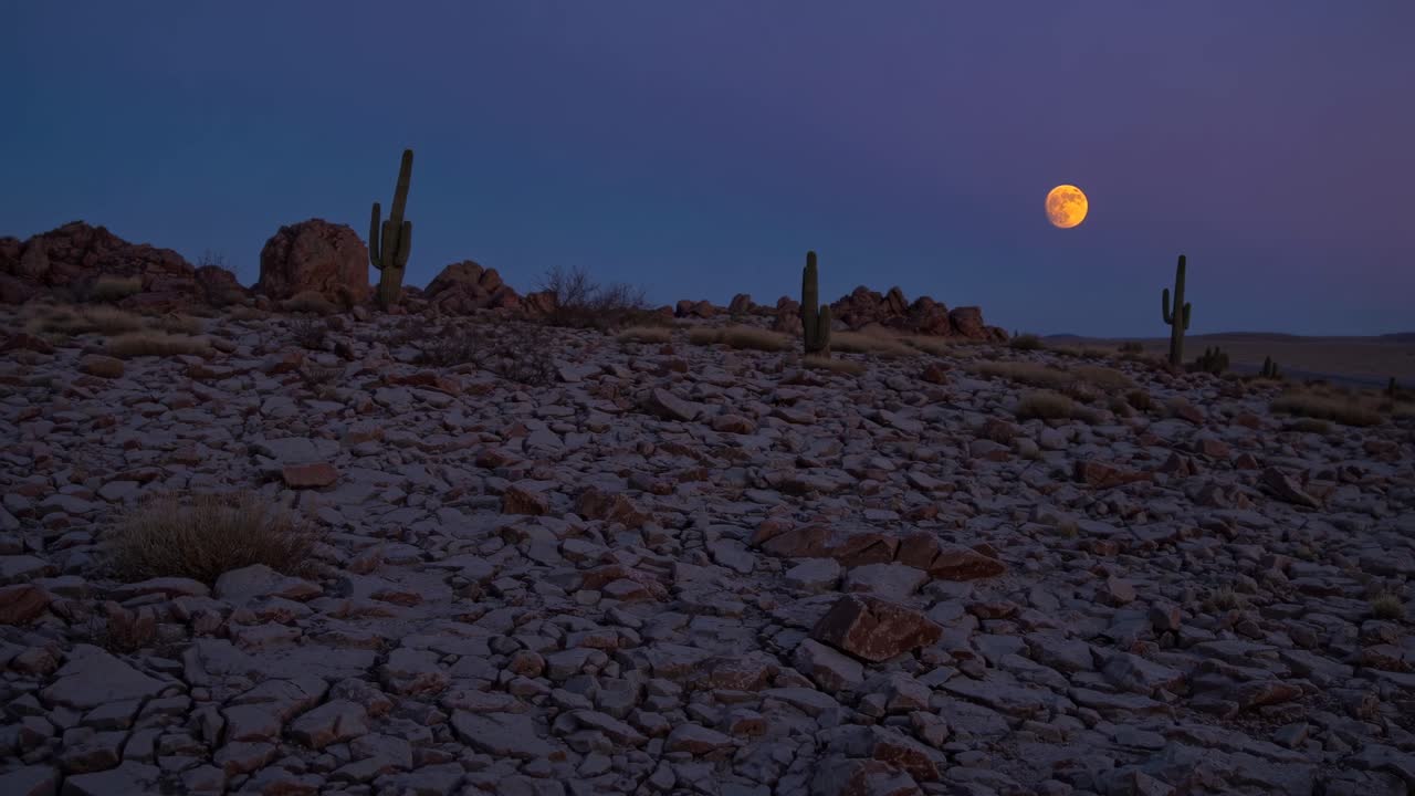 Red Moon over a Rocky Desert Landscape