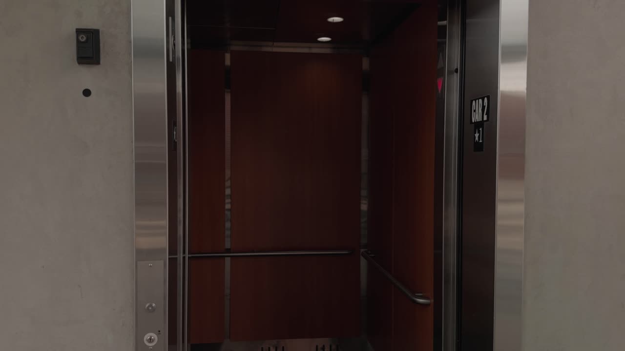 Panorâmica suave em câmera lenta com as portas do elevador abrindo e fechando dentro de um prédio moderno e silencioso