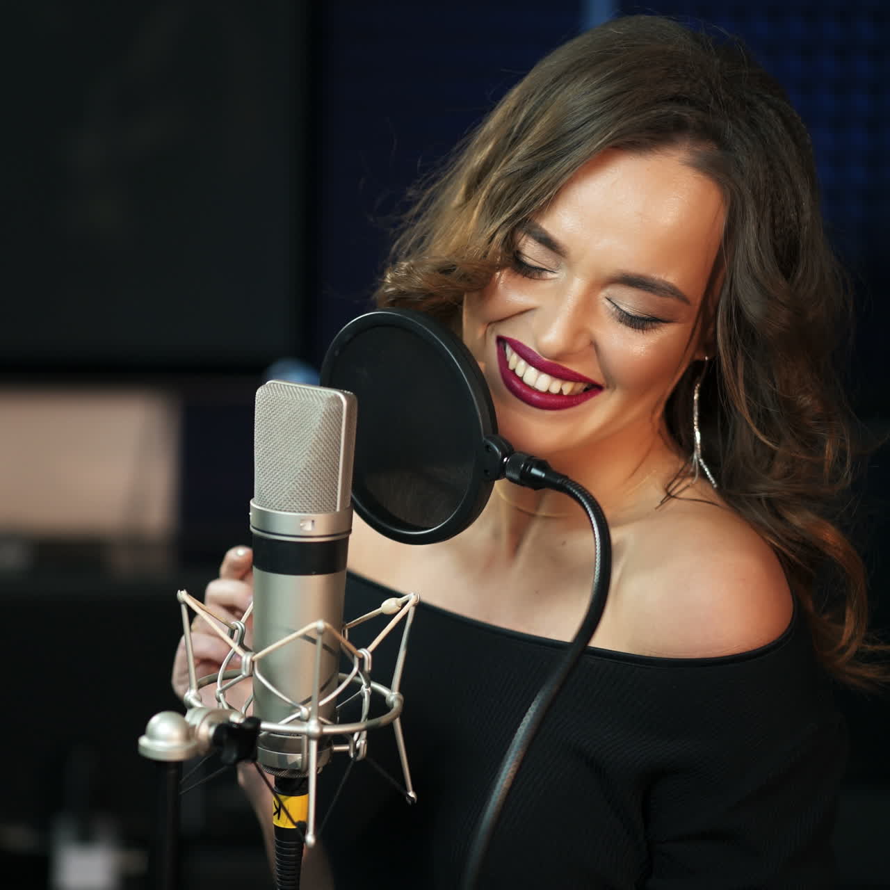 Beautiful girl sings into a microphone in a recording studio. Club retro concert of music. Square video