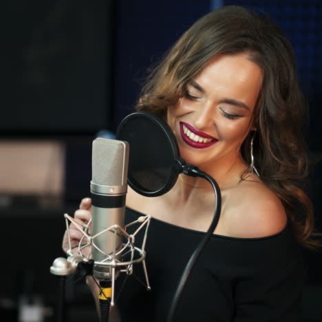 beautiful girl sings into a microphone in a recording studio. club retro concert of music. square video