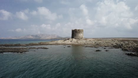 an aerial slow approach to the medieval watchtower built in the xvi century on a small rocky island