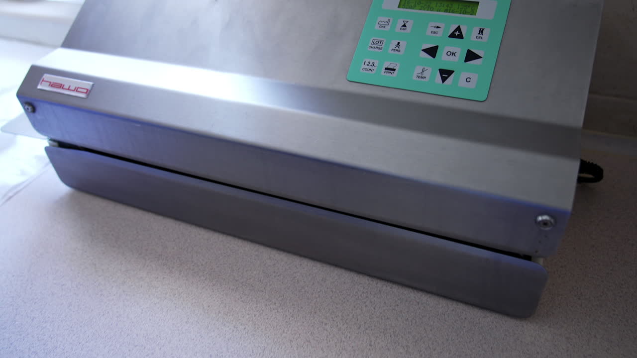 Panel of sensor keys on the equipment for sterilization. Nurse in blue gloves prepares plastic bag for device disinfection in machine. Top view.