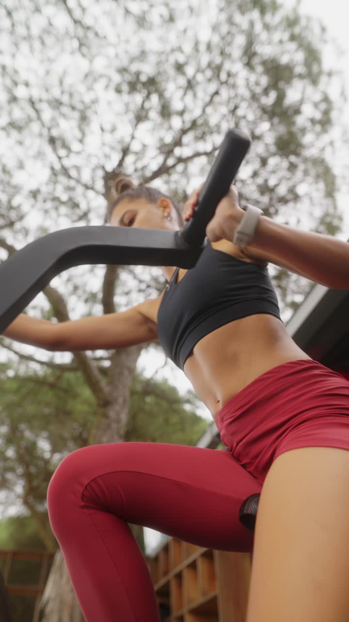 Woman working out on a fitness machine outdoors