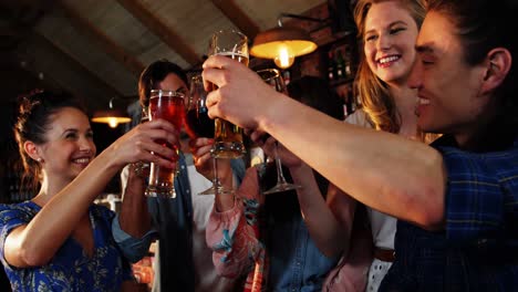 friends toasting drinks together in bar