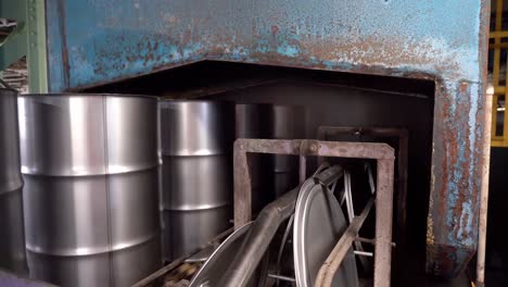 A-conveyor-belt-carries-steel-drum-cans-and-lids-along-the-production-line